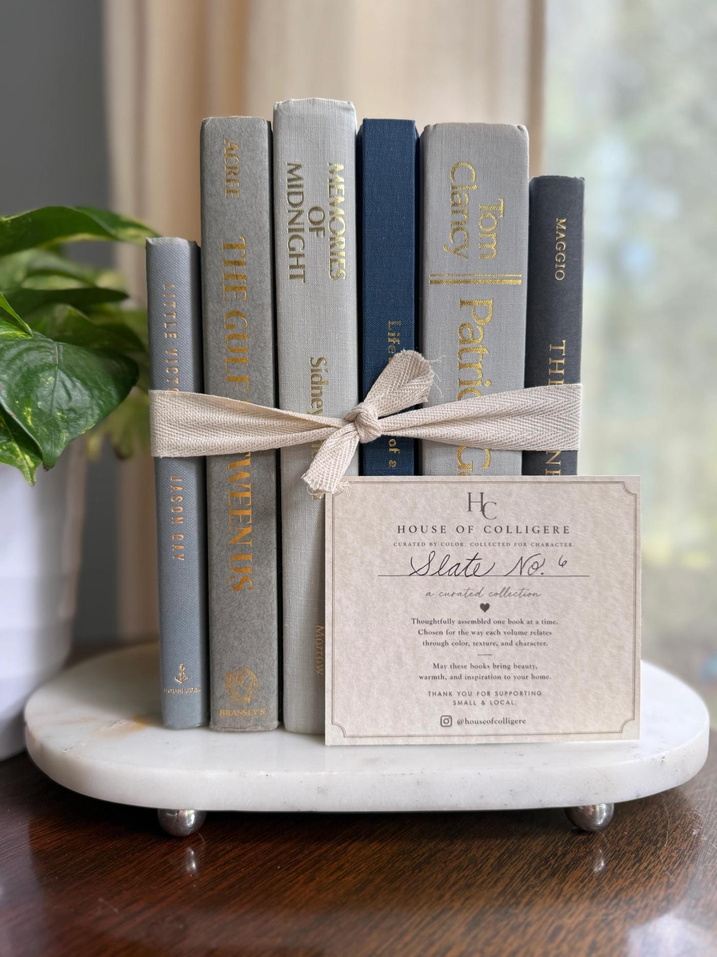 Curated collection of muted blue-gray, slate, charcoal, and softly weathered neutral books.