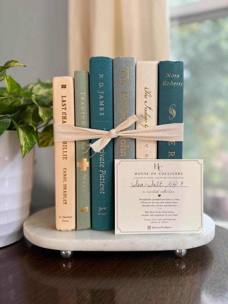 Curated collection of white, pale blue, sand, and soft coastal-neutral books with an airy, sun-faded look.