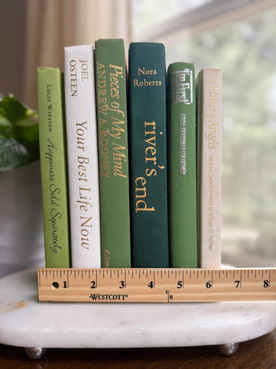 Curated collection of soft sage, olive, cream, and muted green books with botanical tones.