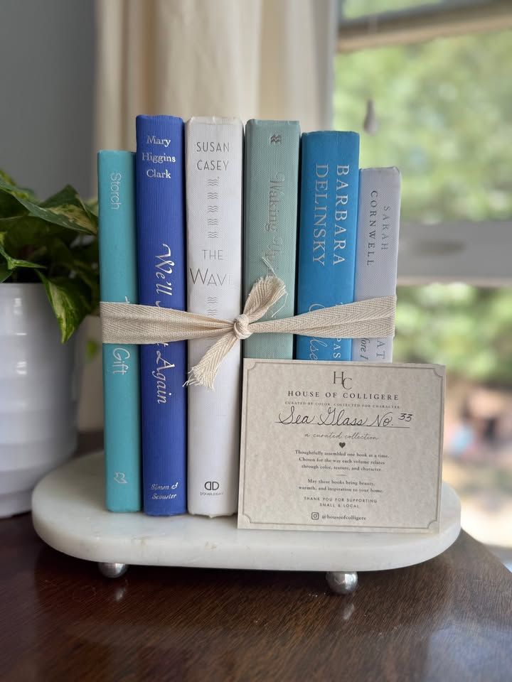 Sea Glass No. 33 decorative book collection in turquoise, cobalt blue, white, pale aqua, and soft gray tones, tied with neutral linen ribbon and styled on a marble table.