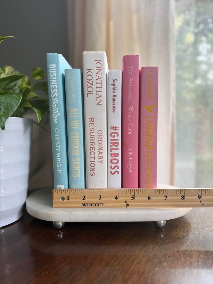 Curated collection of aqua, pale blue, white, and pink books with bright pastel tones and playful contrast.