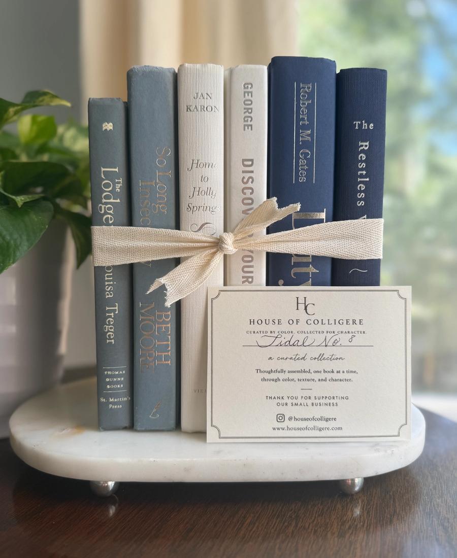 Curated collection of layered blue books ranging from pale coastal blue to deeper ocean tones.