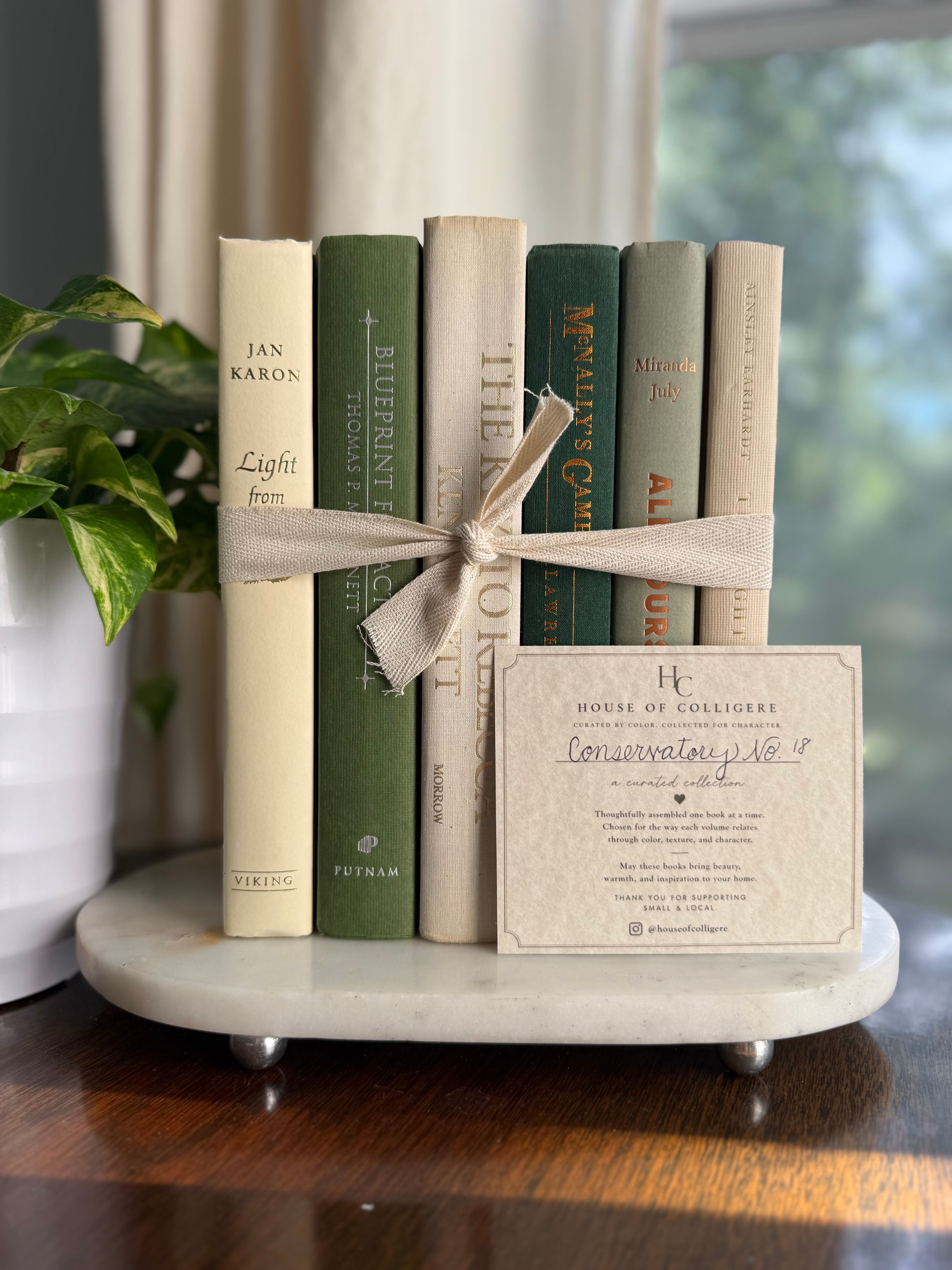 Curated collection of soft sage, olive, cream, and muted green books with botanical tones.