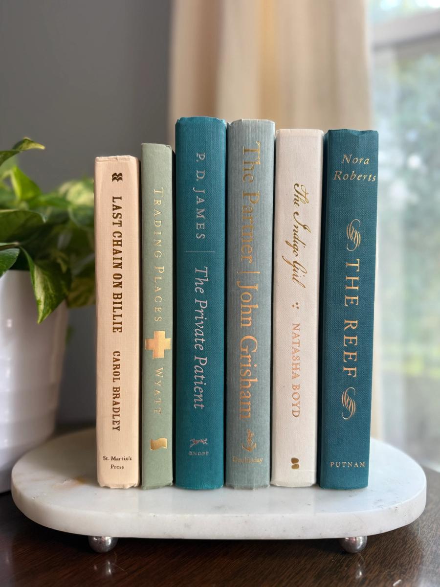 Curated collection of white, pale blue, sand, and soft coastal-neutral books with an airy, sun-faded look.