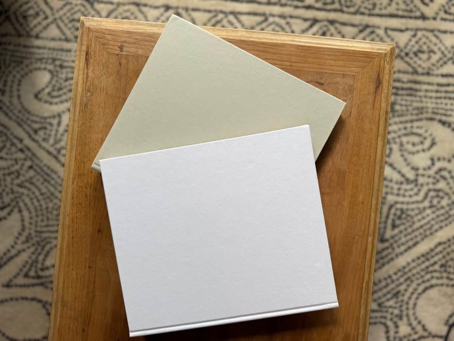 Coffee Table Design, White, beige, almond, linen-like cloth covers, matte woven texture, subtle gold and metallic lettering, understated traditional styling