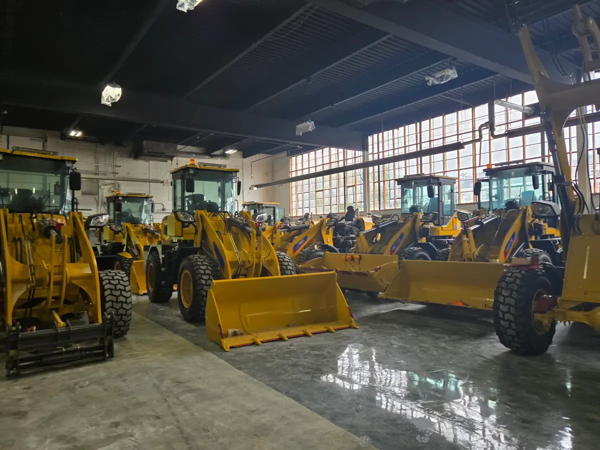 Row of Damstrong compact wheel loaders parked inside an indoor storage facility