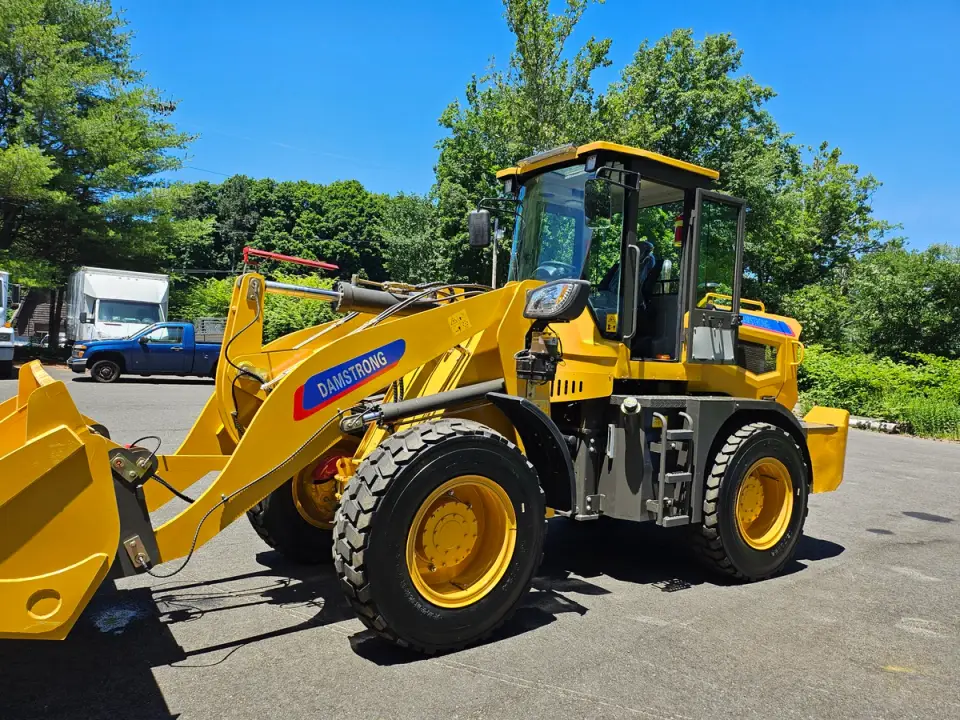 Yellow Damstrong compact wheel loader parked outdoors in a paved lot