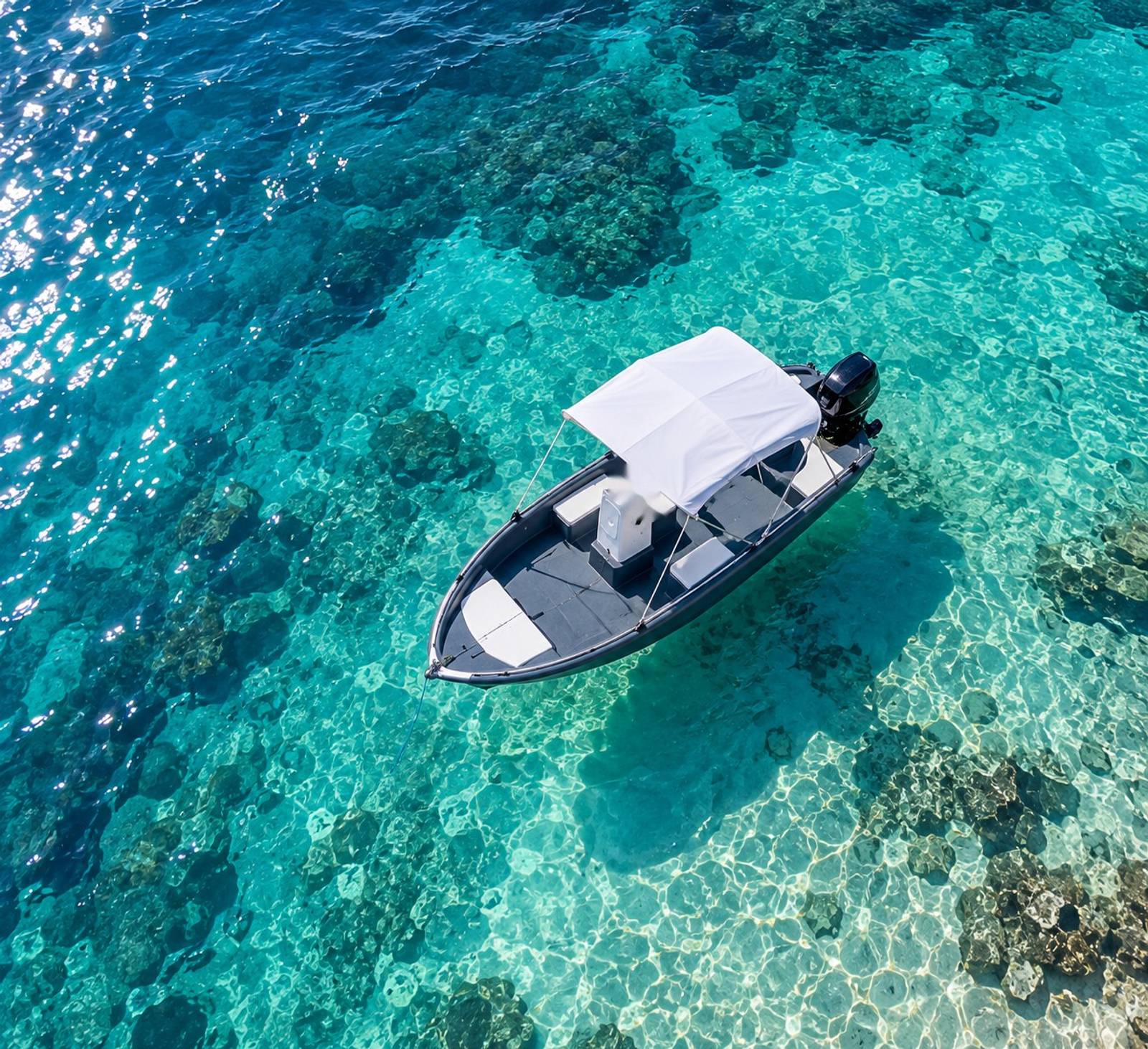 Bateau sans permis Ride & Sea au mouillage au-dessus d'une eau turquoise transparente, vu du ciel