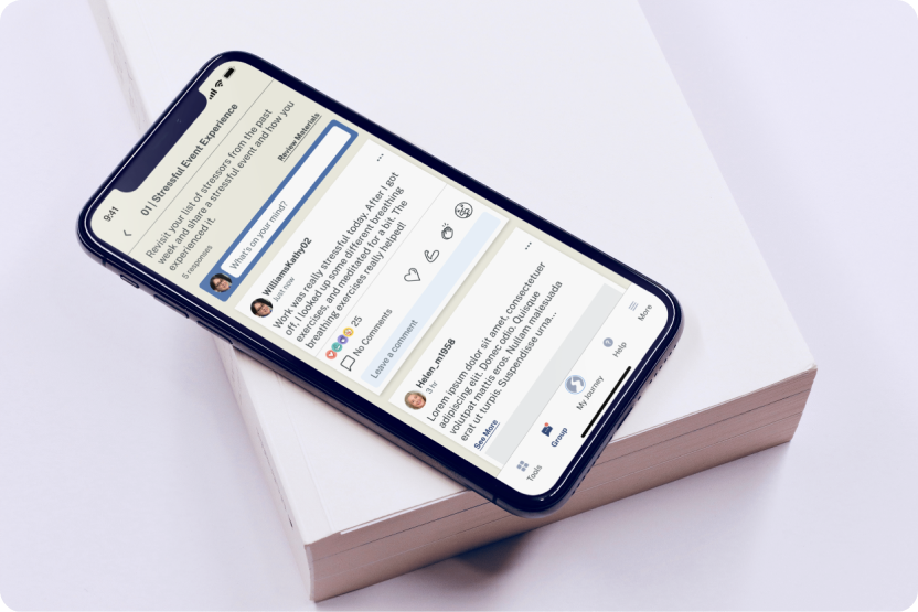 Mobile phone sitting on a white block displaying screen from attune mobile app group chat feed.