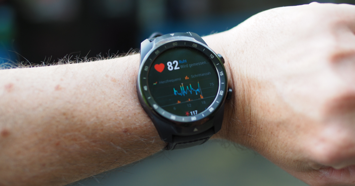 Wrist with digital watch displaying heart rate metrics.