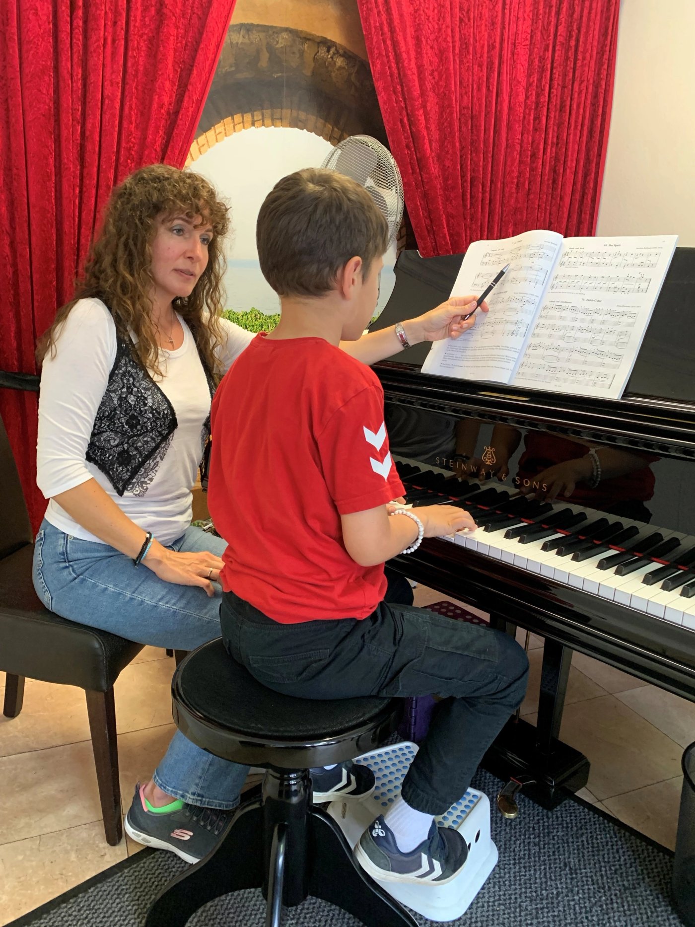 Erika Neufeld und ein Schüler am Konzertflügel im Studio