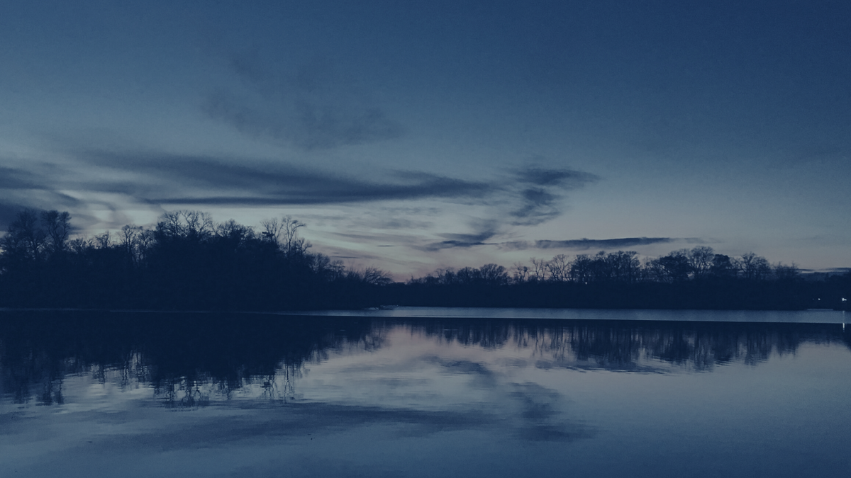 A sunset reflected on the lake, dark blue overlay