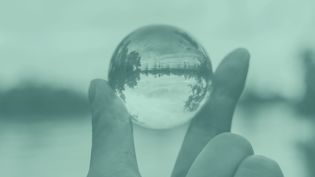 A photo of fingers holding a crystal ball