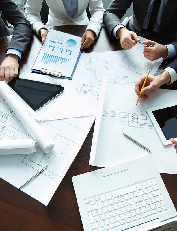 a group of business people are sitting around a table working on a project .