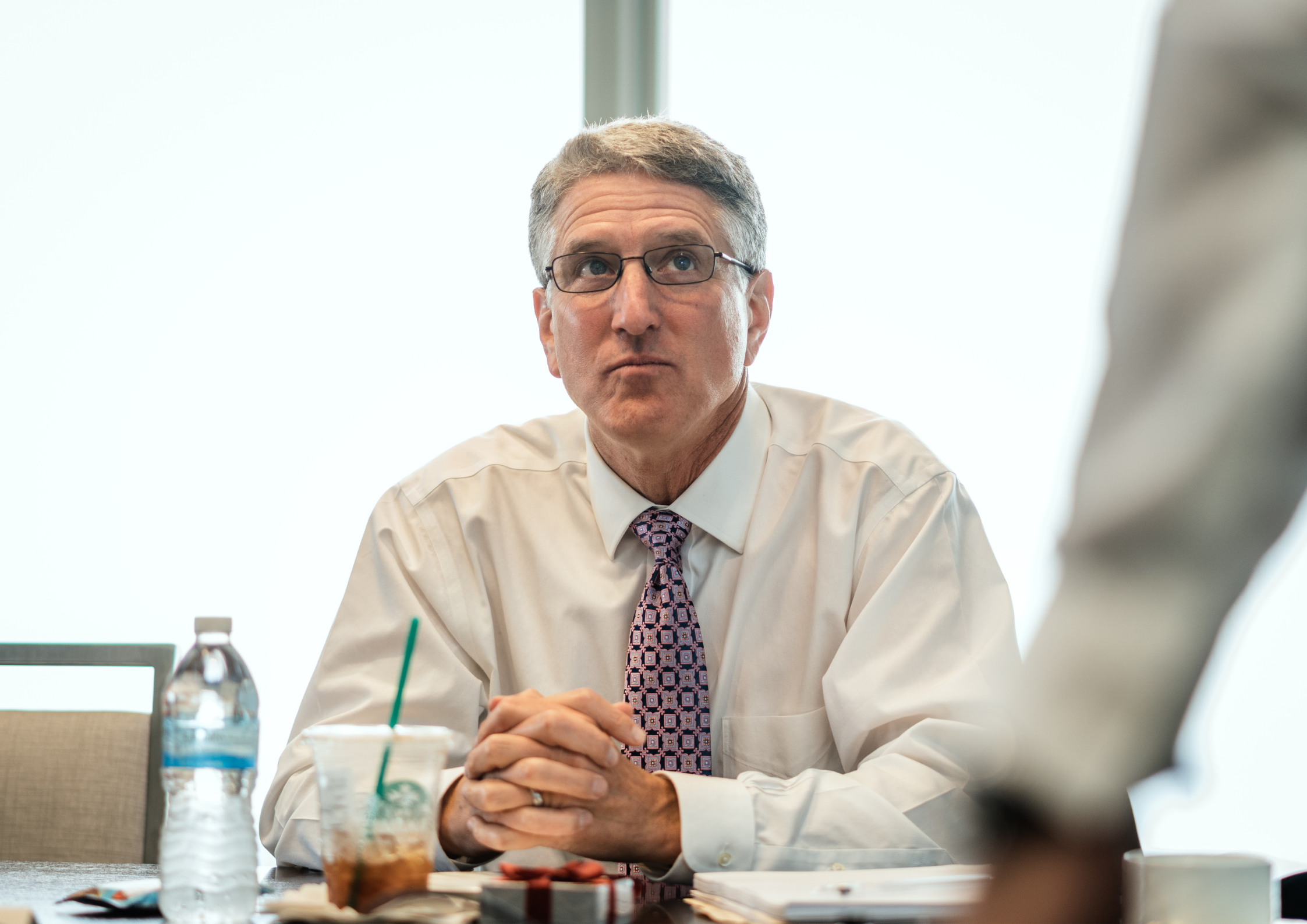 A man with gray hair and glasses in a white shirt and tie sits at a table, hands clasped, looking up. A water bottle and coffee cup are on the table.​​​​‌﻿‍﻿​‍​‍‌‍﻿﻿‌﻿​‍‌‍‍‌‌‍‌﻿‌‍‍‌‌‍﻿‍​‍​‍​﻿‍‍​‍​‍‌﻿​﻿‌‍​‌‌‍﻿‍‌‍‍‌‌﻿‌​‌﻿‍‌​‍﻿‍‌‍‍‌‌‍﻿﻿​‍​‍​‍﻿​​‍​‍‌‍‍​‌﻿​‍‌‍‌‌‌‍‌‍​‍​‍​﻿‍‍​‍​‍‌‍‍​‌﻿‌​‌﻿‌​‌﻿​​‌﻿​﻿​﻿‍‍​‍﻿﻿​‍﻿﻿‌‍﻿‌‌‍​‌‌‍​﻿‌‍‍﻿‌‍​‌‌﻿‍‌​‍﻿‌‌‍‌﻿‌‍﻿﻿‌‍﻿﻿‌‍‌​‌﻿‌﻿‌‍‍‌‌‍﻿‍​‍﻿‍‌﻿​﻿‌‍​‌‌‍﻿‍‌‍‍‌‌﻿‌​‌﻿‍‌​‍﻿‍‌﻿​﻿‌﻿‌​‌﻿‌‌‌‍‌​‌‍‍‌‌‍﻿﻿​‍﻿﻿‌﻿​﻿‌﻿‌​‌﻿‌‌‌‍‌​‌‍‍‌‌‍﻿﻿​‍﻿﻿‌‍‍‌‌‍﻿‍‌﻿‌​‌‍‌‌‌‍﻿‍‌﻿‌​​‍﻿﻿‌‍‌‌‌‍‌​‌‍‍‌‌﻿‌​​‍﻿﻿‌‍﻿‌‌‍﻿﻿‌‍‌​‌‍‌‌​﻿﻿‌‌﻿​​‌﻿​‍‌‍‌‌‌﻿​﻿‌‍‌‌‌‍﻿‍‌﻿‌​‌‍​‌‌﻿‌​‌‍‍‌‌‍﻿﻿‌‍﻿‍​﻿‍﻿‌‍‍‌‌‍‌​​﻿﻿‌​﻿‍​​﻿‍​​﻿‍​​﻿‌﻿​﻿‌‌​﻿‌‌​﻿‍​​﻿‍​​‍﻿‌‌‍​‌​﻿​​‌‍​﻿​﻿​‌​‍﻿‌​﻿‌​​﻿‍‌‌‍‌‍​﻿​​​‍﻿‌​﻿‍​‌‍​﻿​﻿‌​​﻿​​​‍﻿‌​﻿‌﻿​﻿​​​﻿​‌‌‍​‍​﻿‌‌‌‍​‌​﻿‍‌​﻿‌‍​﻿‌‌‌‍‌‌​﻿​‌​﻿​​​﻿‍﻿‌﻿‌​‌﻿‍‌‌﻿​​‌‍‌‌​﻿﻿‌‌﻿​​‌‍﻿﻿‌﻿​﻿‌﻿‌​​﻿‍﻿‌﻿​​‌‍​‌‌﻿‌​‌‍‍​​﻿﻿‌‌‍‍‌‌‍﻿‌‌‍​‌‌‍‌﻿‌‍‌‌​‍﻿‍‌‍​‌‌‍﻿​‌﻿‌​​﻿﻿﻿‌‍​‍‌‍​‌‌﻿​﻿‌‍‌‌‌‌‌‌‌﻿​‍‌‍﻿​​﻿﻿‌‌‍‍​‌﻿‌​‌﻿‌​‌﻿​​‌﻿​﻿​‍‌‌​﻿​﻿‌​​‌​‍‌‌​﻿​‍‌​‌‍​‍‌‌​﻿​‍‌​‌‍‌‍﻿‌‌‍​‌‌‍​﻿‌‍‍﻿‌‍​‌‌﻿‍‌​‍﻿‌‌‍‌﻿‌‍﻿﻿‌‍﻿﻿‌‍‌​‌﻿‌﻿‌‍‍‌‌‍﻿‍​‍﻿‍‌﻿​﻿‌‍​‌‌‍﻿‍‌‍‍‌‌﻿‌​‌﻿‍‌​‍﻿‍‌﻿​﻿‌﻿‌​‌﻿‌‌‌‍‌​‌‍‍‌‌‍﻿﻿​‍‌‌​﻿​‍‌​‌‍‌﻿​﻿‌﻿‌​‌﻿‌‌‌‍‌​‌‍‍‌‌‍﻿﻿​‍‌‍‌‍‍‌‌‍‌​​﻿﻿‌​﻿‍​​﻿‍​​﻿‍​​﻿‌﻿​﻿‌‌​﻿‌‌​﻿‍​​﻿‍​​‍﻿‌‌‍​‌​﻿​​‌‍​﻿​﻿​‌​‍﻿‌​﻿‌​​﻿‍‌‌‍‌‍​﻿​​​‍﻿‌​﻿‍​‌‍​﻿​﻿‌​​﻿​​​‍﻿‌​﻿‌﻿​﻿​​​﻿​‌‌‍​‍​﻿‌‌‌‍​‌​﻿‍‌​﻿‌‍​﻿‌‌‌‍‌‌​﻿​‌​﻿​​​‍‌‍‌﻿‌​‌﻿‍‌‌﻿​​‌‍‌‌​﻿﻿‌‌﻿​​‌‍﻿﻿‌﻿​﻿‌﻿‌​​‍‌‍‌﻿​​‌‍​‌‌﻿‌​‌‍‍​​﻿﻿‌‌‍‍‌‌‍﻿‌‌‍​‌‌‍‌﻿‌‍‌‌​‍﻿‍‌‍​‌‌‍﻿​‌﻿‌​​‍‌‍‌﻿​​‌‍‌‌‌﻿​‍‌﻿​﻿‌﻿​​‌‍‌‌‌‍​﻿‌﻿‌​‌‍‍‌‌﻿‌‍‌‍‌‌​﻿﻿‌‌﻿​​‌﻿‌‌‌‍​‍‌‍﻿​‌‍‍‌‌﻿​﻿‌‍‍​‌‍‌‌‌‍‌​​‍​‍‌﻿﻿‌