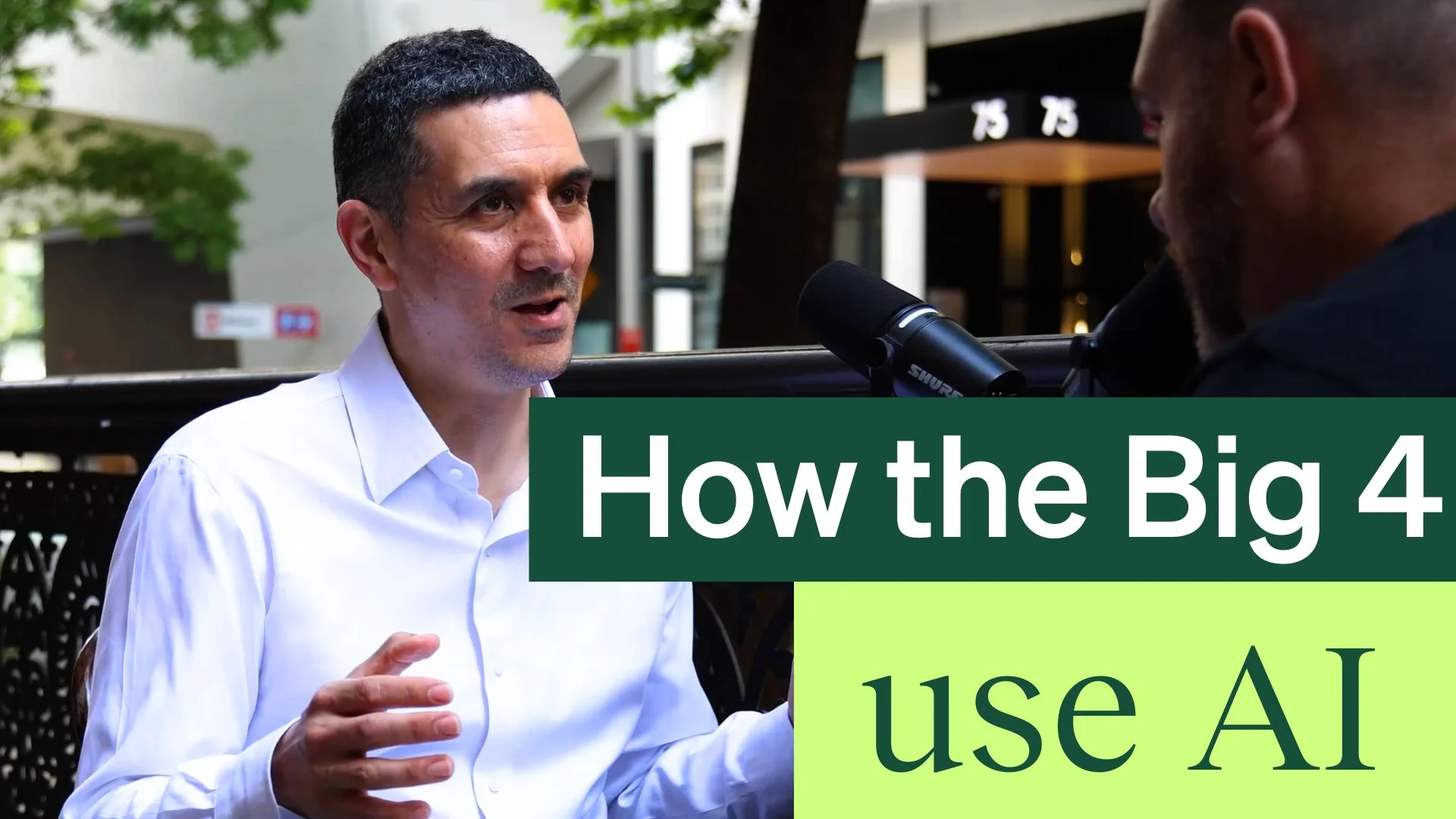 A man in a white shirt speaks during an outdoor interview, with text overlay: "How the Big 4 use AI."