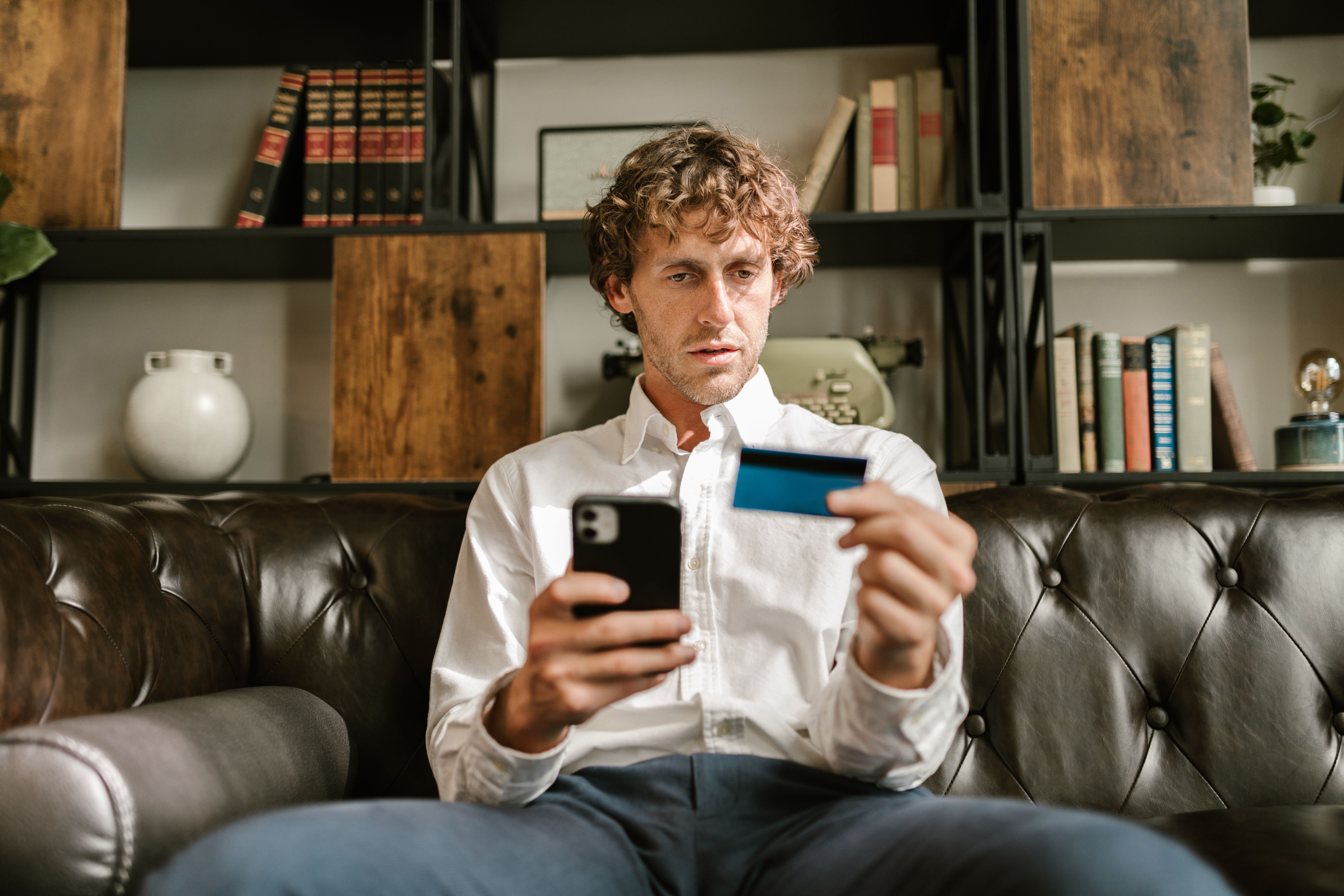 Man on a couch using his smartphone and holding a credit card.​​​​‌﻿‍﻿​‍​‍‌‍﻿﻿‌﻿​‍‌‍‍‌‌‍‌﻿‌‍‍‌‌‍﻿‍​‍​‍​﻿‍‍​‍​‍‌﻿​﻿‌‍​‌‌‍﻿‍‌‍‍‌‌﻿‌​‌﻿‍‌​‍﻿‍‌‍‍‌‌‍﻿﻿​‍​‍​‍﻿​​‍​‍‌‍‍​‌﻿​‍‌‍‌‌‌‍‌‍​‍​‍​﻿‍‍​‍​‍‌‍‍​‌﻿‌​‌﻿‌​‌﻿​​‌﻿​﻿​﻿‍‍​‍﻿﻿​‍﻿﻿‌‍﻿‌‌‍​‌‌‍​﻿‌‍‍﻿‌‍​‌‌﻿‍‌​‍﻿‌‌‍‌﻿‌‍﻿﻿‌‍﻿﻿‌‍‌​‌﻿‌﻿‌‍‍‌‌‍﻿‍​‍﻿‍‌﻿​﻿‌‍​‌‌‍﻿‍‌‍‍‌‌﻿‌​‌﻿‍‌​‍﻿‍‌﻿​﻿‌﻿‌​‌﻿‌‌‌‍‌​‌‍‍‌‌‍﻿﻿​‍﻿﻿‌﻿​﻿‌﻿‌​‌﻿‌‌‌‍‌​‌‍‍‌‌‍﻿﻿​‍﻿﻿‌‍‍‌‌‍﻿‍‌﻿‌​‌‍‌‌‌‍﻿‍‌﻿‌​​‍﻿﻿‌‍‌‌‌‍‌​‌‍‍‌‌﻿‌​​‍﻿﻿‌‍﻿‌‌‍﻿﻿‌‍‌​‌‍‌‌​﻿﻿‌‌﻿​​‌﻿​‍‌‍‌‌‌﻿​﻿‌‍‌‌‌‍﻿‍‌﻿‌​‌‍​‌‌﻿‌​‌‍‍‌‌‍﻿﻿‌‍﻿‍​﻿‍﻿‌‍‍‌‌‍‌​​﻿﻿‌​﻿​​‌‍​‍‌‍​‌‌‍‌‍​﻿‌﻿​﻿​‌​﻿​﻿​﻿​‌​‍﻿‌​﻿‍‌‌‍‌‌‌‍​‌​﻿‌‌​‍﻿‌​﻿‌​​﻿‍‌​﻿‍​‌‍‌‌​‍﻿‌​﻿‍‌​﻿‌‍​﻿‌‍​﻿‍​​‍﻿‌​﻿‌﻿​﻿‍‌‌‍‌‍‌‍‌​​﻿‌‌​﻿‌​​﻿‍​‌‍‌​‌‍​‌‌‍​﻿​﻿‌﻿‌‍​‍​﻿‍﻿‌﻿‌​‌﻿‍‌‌﻿​​‌‍‌‌​﻿﻿‌‌﻿​​‌‍﻿﻿‌﻿​﻿‌﻿‌​​﻿‍﻿‌﻿​​‌‍​‌‌﻿‌​‌‍‍​​﻿﻿‌‌‍‍‌‌‍﻿‌‌‍​‌‌‍‌﻿‌‍‌‌​‍﻿‍‌‍​‌‌‍﻿​‌﻿‌​​﻿﻿﻿‌‍​‍‌‍​‌‌﻿​﻿‌‍‌‌‌‌‌‌‌﻿​‍‌‍﻿​​﻿﻿‌‌‍‍​‌﻿‌​‌﻿‌​‌﻿​​‌﻿​﻿​‍‌‌​﻿​﻿‌​​‌​‍‌‌​﻿​‍‌​‌‍​‍‌‌​﻿​‍‌​‌‍‌‍﻿‌‌‍​‌‌‍​﻿‌‍‍﻿‌‍​‌‌﻿‍‌​‍﻿‌‌‍‌﻿‌‍﻿﻿‌‍﻿﻿‌‍‌​‌﻿‌﻿‌‍‍‌‌‍﻿‍​‍﻿‍‌﻿​﻿‌‍​‌‌‍﻿‍‌‍‍‌‌﻿‌​‌﻿‍‌​‍﻿‍‌﻿​﻿‌﻿‌​‌﻿‌‌‌‍‌​‌‍‍‌‌‍﻿﻿​‍‌‌​﻿​‍‌​‌‍‌﻿​﻿‌﻿‌​‌﻿‌‌‌‍‌​‌‍‍‌‌‍﻿﻿​‍‌‍‌‍‍‌‌‍‌​​﻿﻿‌​﻿​​‌‍​‍‌‍​‌‌‍‌‍​﻿‌﻿​﻿​‌​﻿​﻿​﻿​‌​‍﻿‌​﻿‍‌‌‍‌‌‌‍​‌​﻿‌‌​‍﻿‌​﻿‌​​﻿‍‌​﻿‍​‌‍‌‌​‍﻿‌​﻿‍‌​﻿‌‍​﻿‌‍​﻿‍​​‍﻿‌​﻿‌﻿​﻿‍‌‌‍‌‍‌‍‌​​﻿‌‌​﻿‌​​﻿‍​‌‍‌​‌‍​‌‌‍​﻿​﻿‌﻿‌‍​‍​‍‌‍‌﻿‌​‌﻿‍‌‌﻿​​‌‍‌‌​﻿﻿‌‌﻿​​‌‍﻿﻿‌﻿​﻿‌﻿‌​​‍‌‍‌﻿​​‌‍​‌‌﻿‌​‌‍‍​​﻿﻿‌‌‍‍‌‌‍﻿‌‌‍​‌‌‍‌﻿‌‍‌‌​‍﻿‍‌‍​‌‌‍﻿​‌﻿‌​​‍‌‍‌﻿​​‌‍‌‌‌﻿​‍‌﻿​﻿‌﻿​​‌‍‌‌‌‍​﻿‌﻿‌​‌‍‍‌‌﻿‌‍‌‍‌‌​﻿﻿‌‌﻿​​‌﻿‌‌‌‍​‍‌‍﻿​‌‍‍‌‌﻿​﻿‌‍‍​‌‍‌‌‌‍‌​​‍​‍‌﻿﻿‌