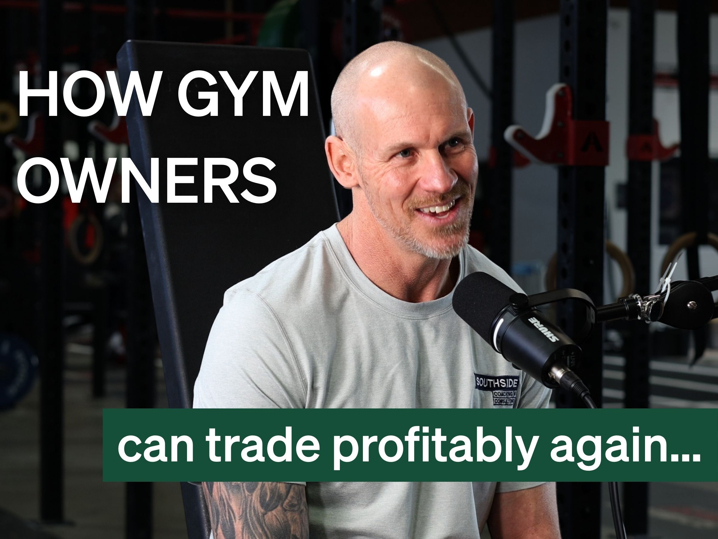 Bald man smiling and speaking into a microphone in a gym, with text "HOW GYM OWNERS can trade profitably again...".