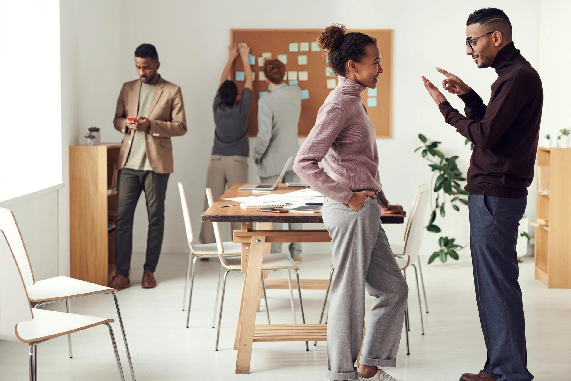 a group of people are standing around a table in an office .