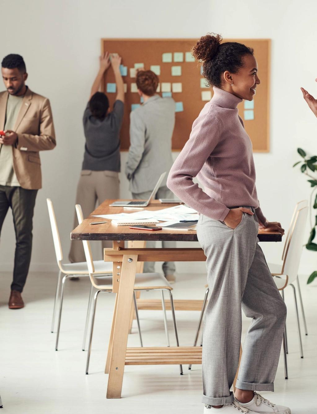 a group of people are standing around a table in an office .