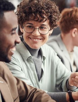 a group of people are sitting at a table looking at a piece of paper .