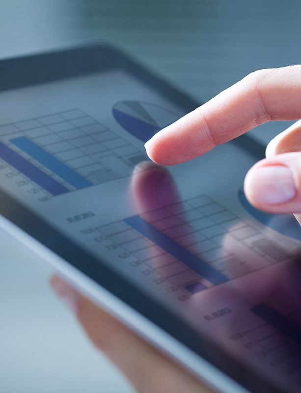 a person is using a tablet computer with a graph on the screen .