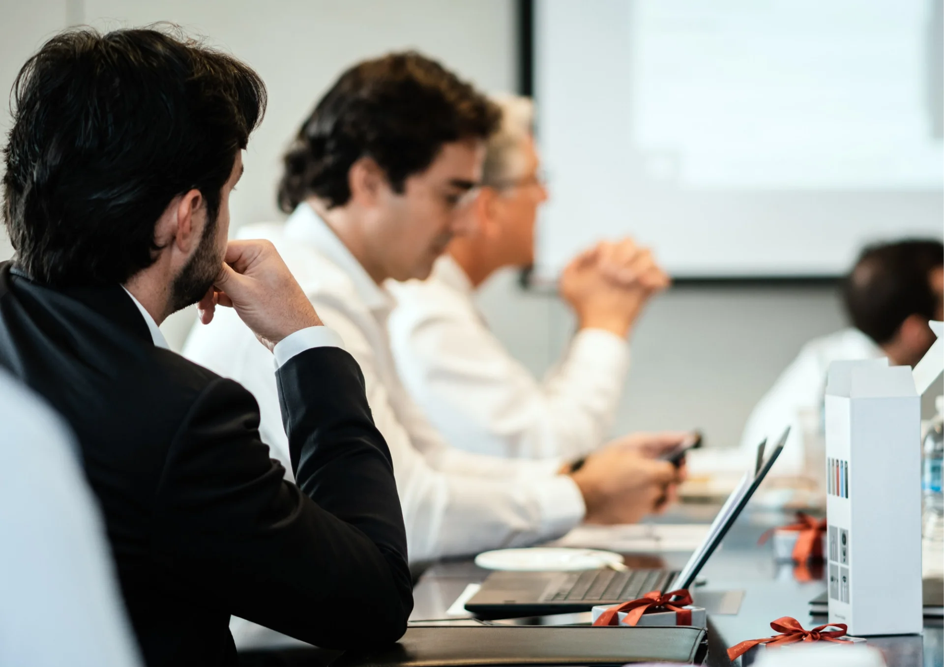 a man and a woman are looking at a laptop computer in an office .