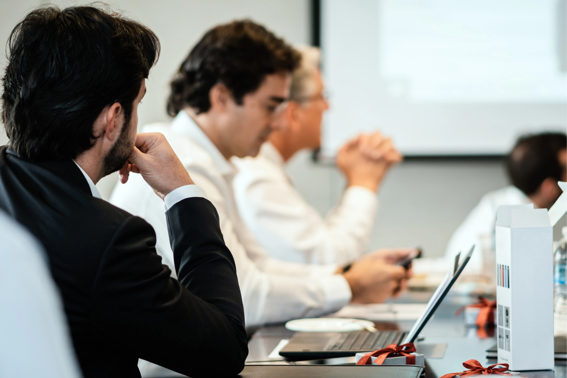 a man and a woman are looking at a laptop computer in an office .