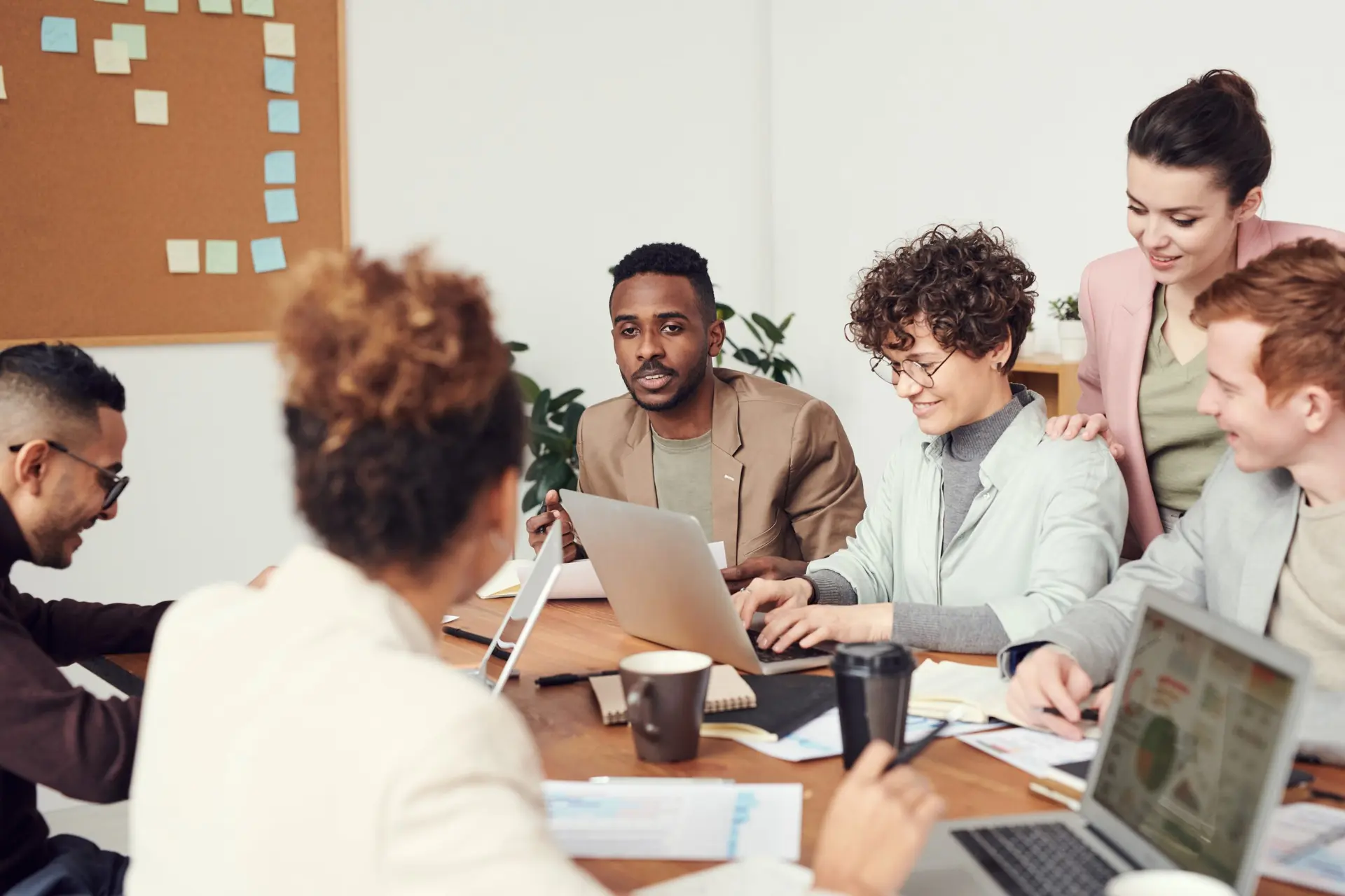 a group of people are sitting around a table in a conference room having a meeting .