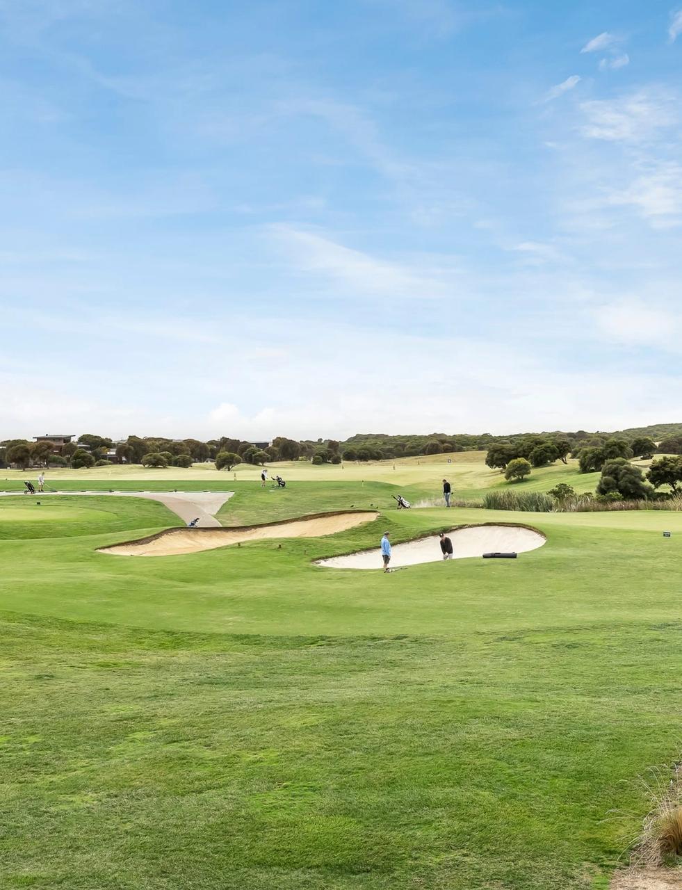 a group of people are playing golf on a golf course .
