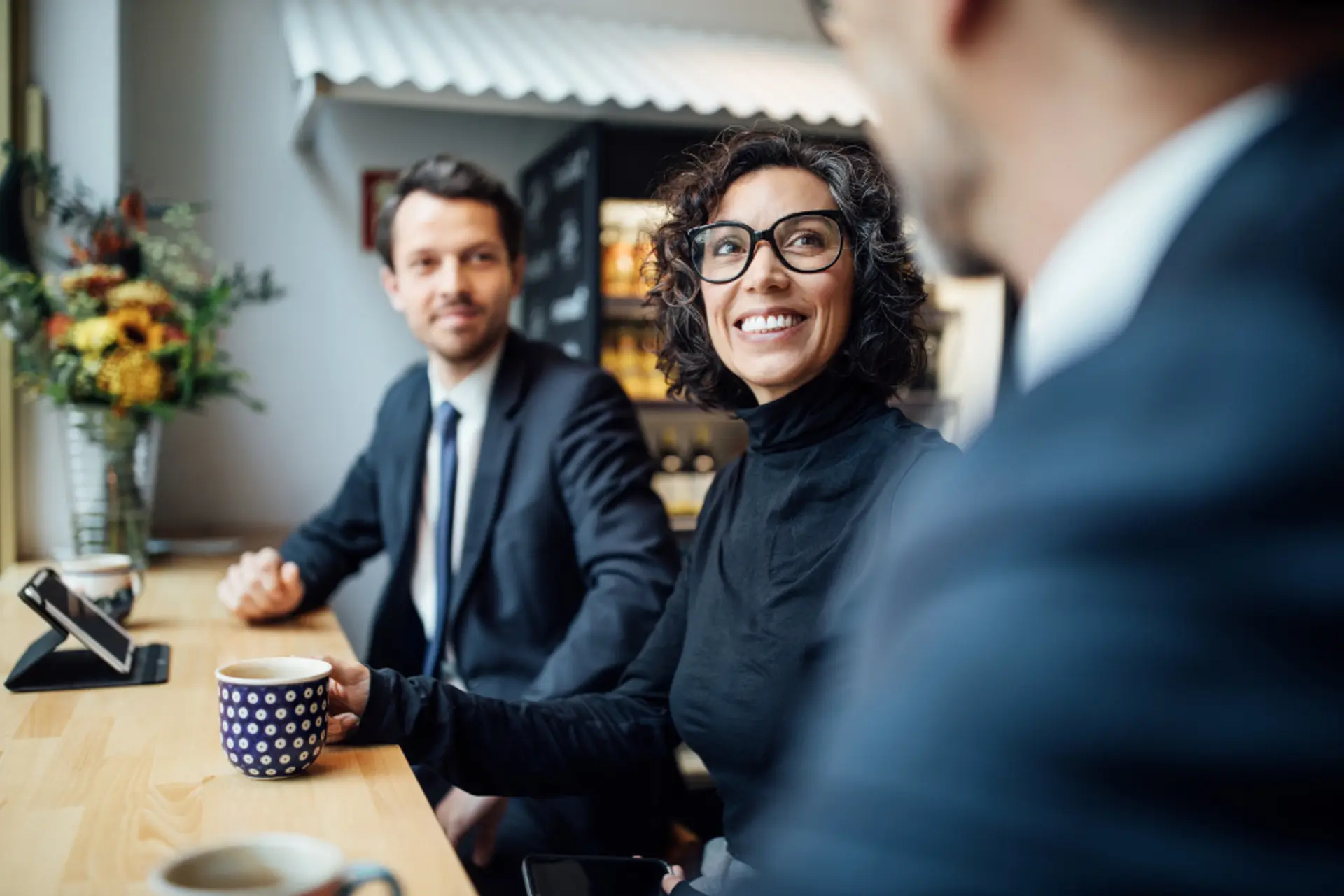 a group of business people are sitting at a table having a meeting .