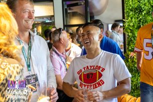 a man in a football shirt is laughing in a crowd of people .