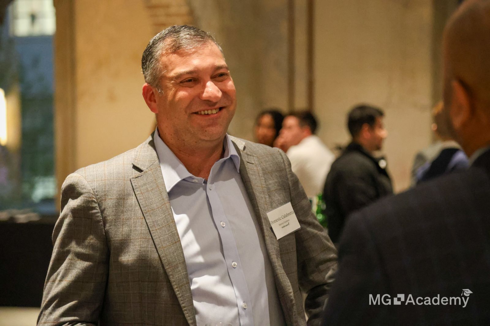 a man in a suit is talking to another man in a room .