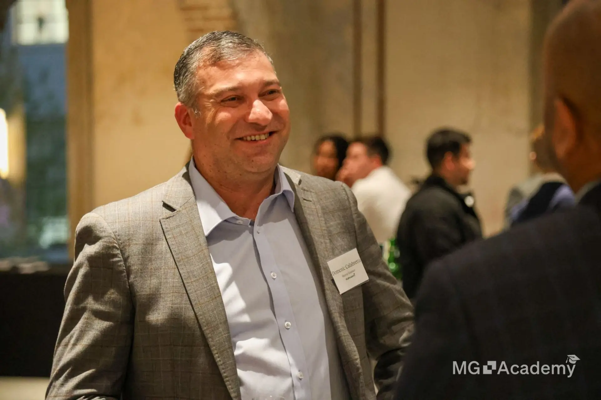 a man in a suit is talking to another man in a room .