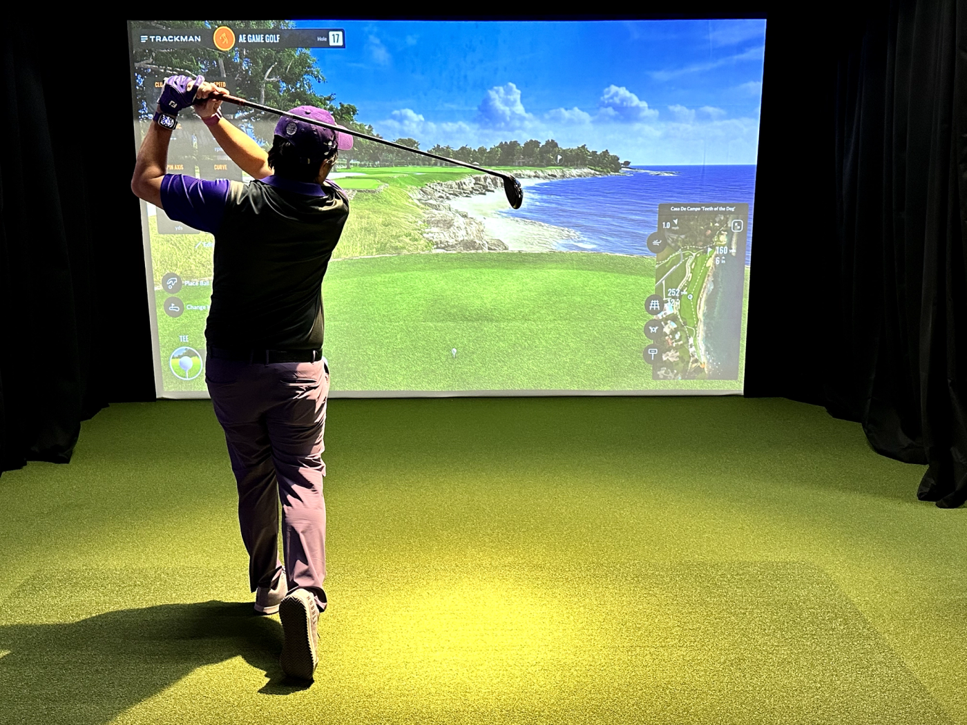 Golfer practicing in a private TrackMan simulator bay.