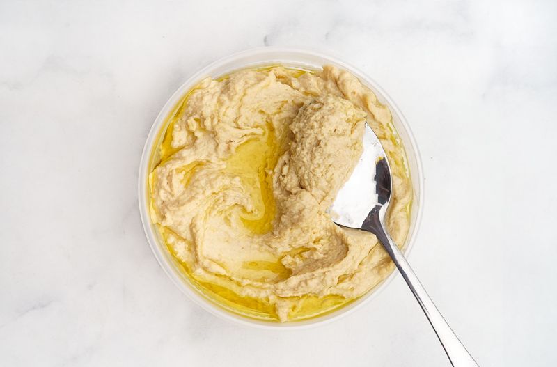 Hummus in container with spoon