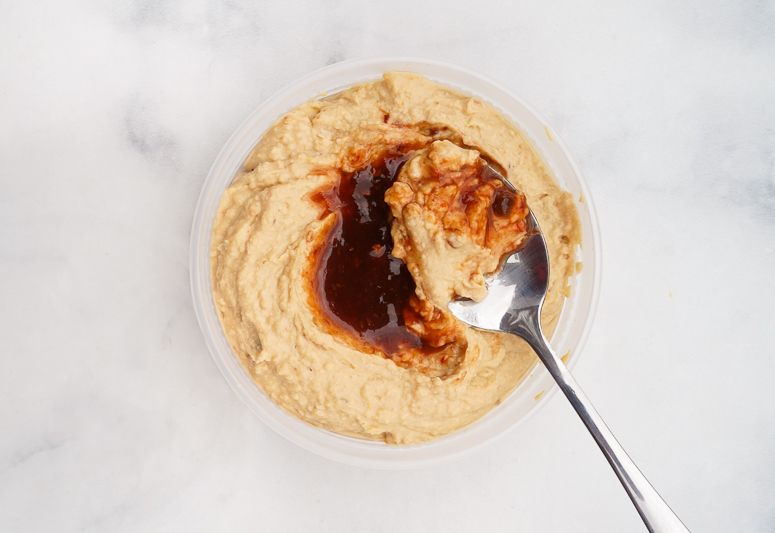 Sweet and Spicy hummus in container with spoon.