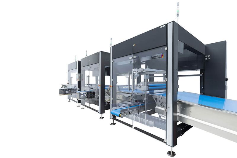 A LoeschPack LOMATIC feeding system carrying product towards a wrapper.