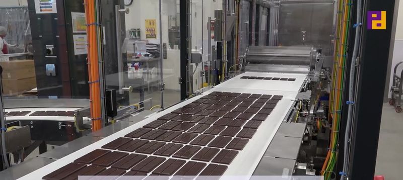 Chocolate bars running through a LoeschPack fold wrapping line.