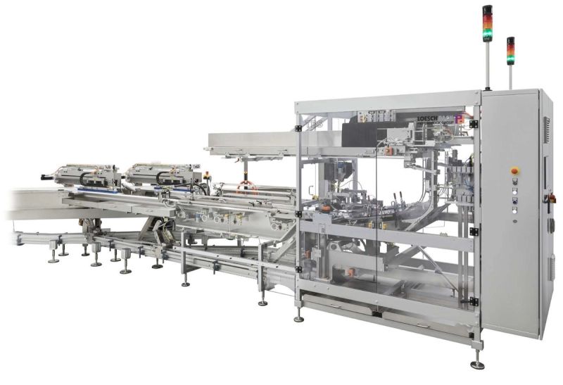 A LoeschPack tray loader placing finished packs into trays at end of line.