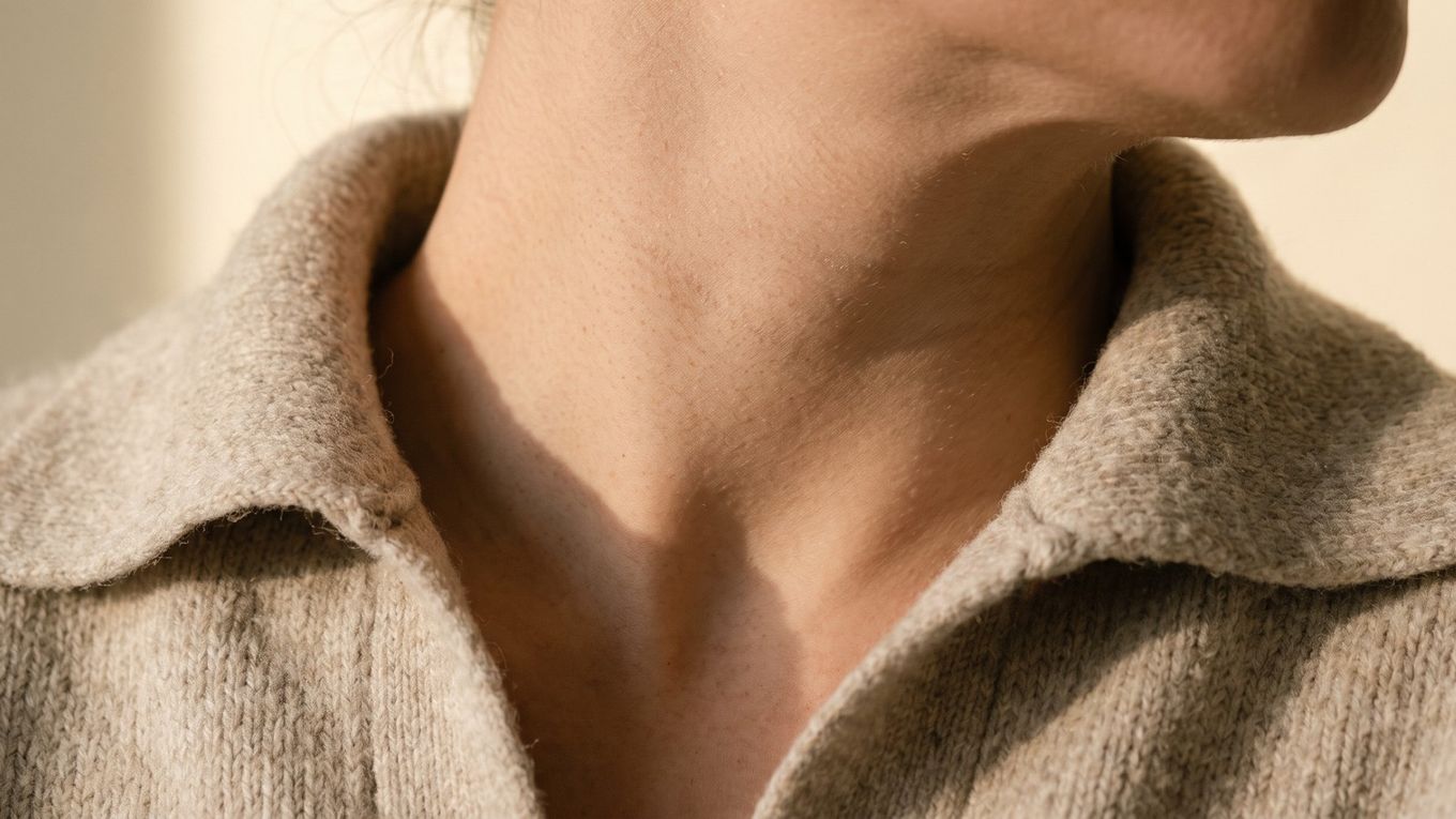 Skin of the front of the neck and under the jaw above a knit collar; the face and neck get sun all year round