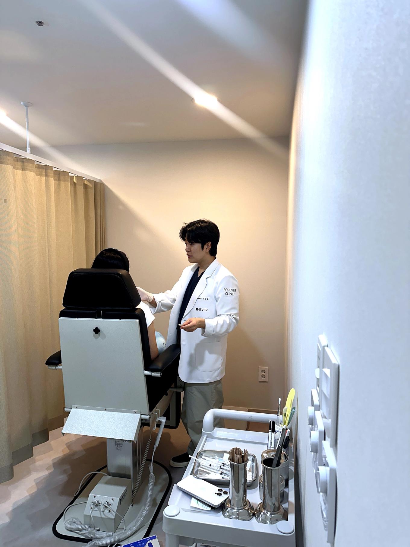 Real photo of a doctor preparing for a filler procedure by assessing facial structure at our clinic in Myeongdong