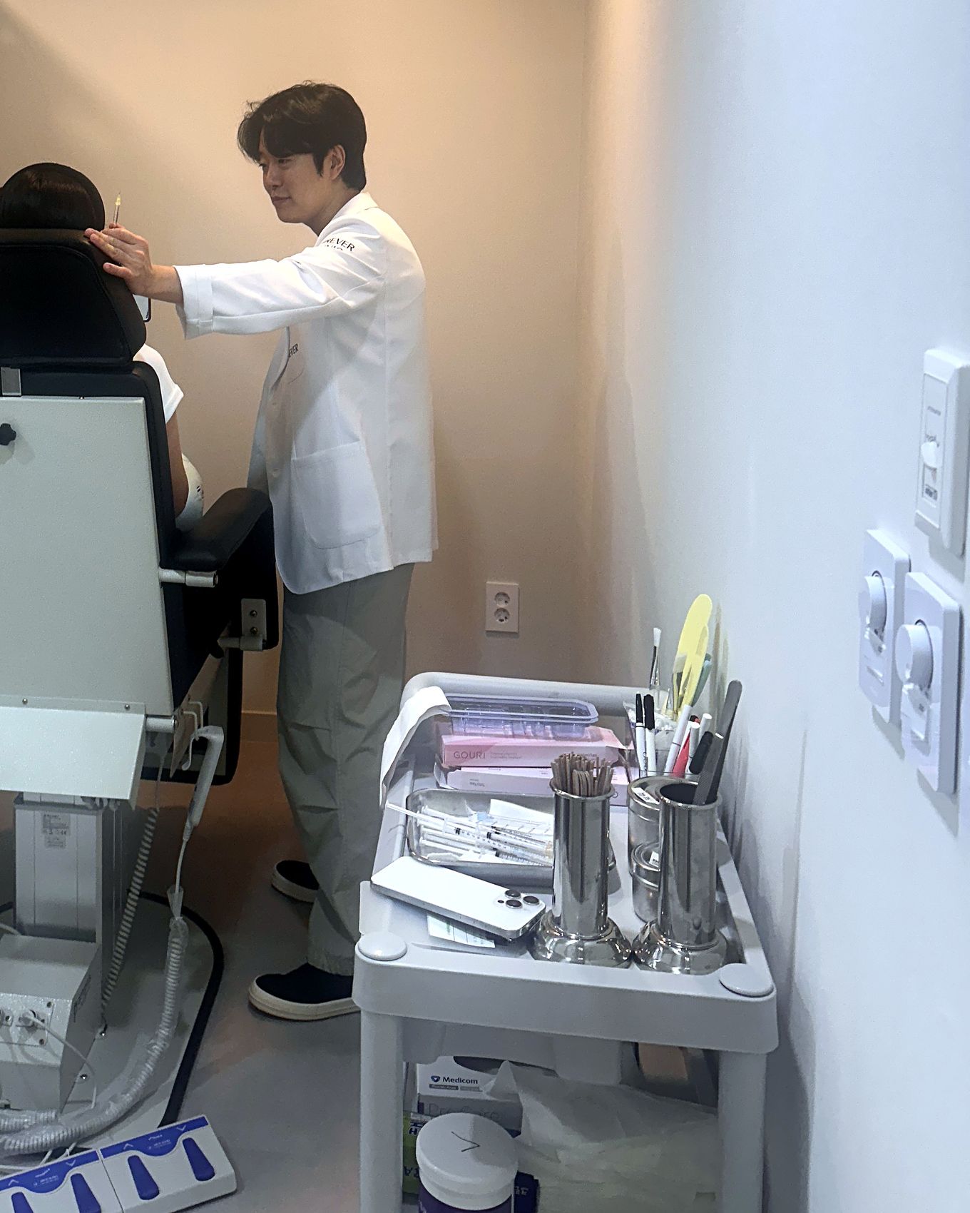 Dr. Chanjong Lee checking area and depth in the treatment room during a collagen booster procedure