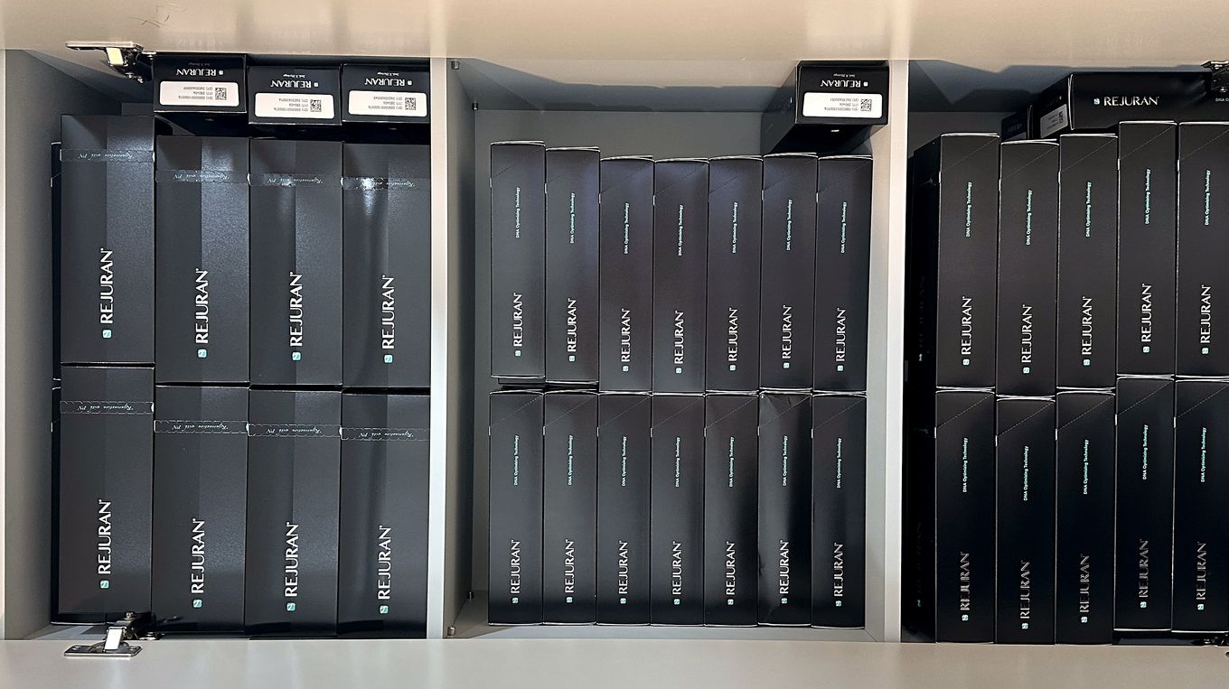 Genuine Rejuran boxes lined up in the cabinet, with QR codes and serial labels on the top of each box