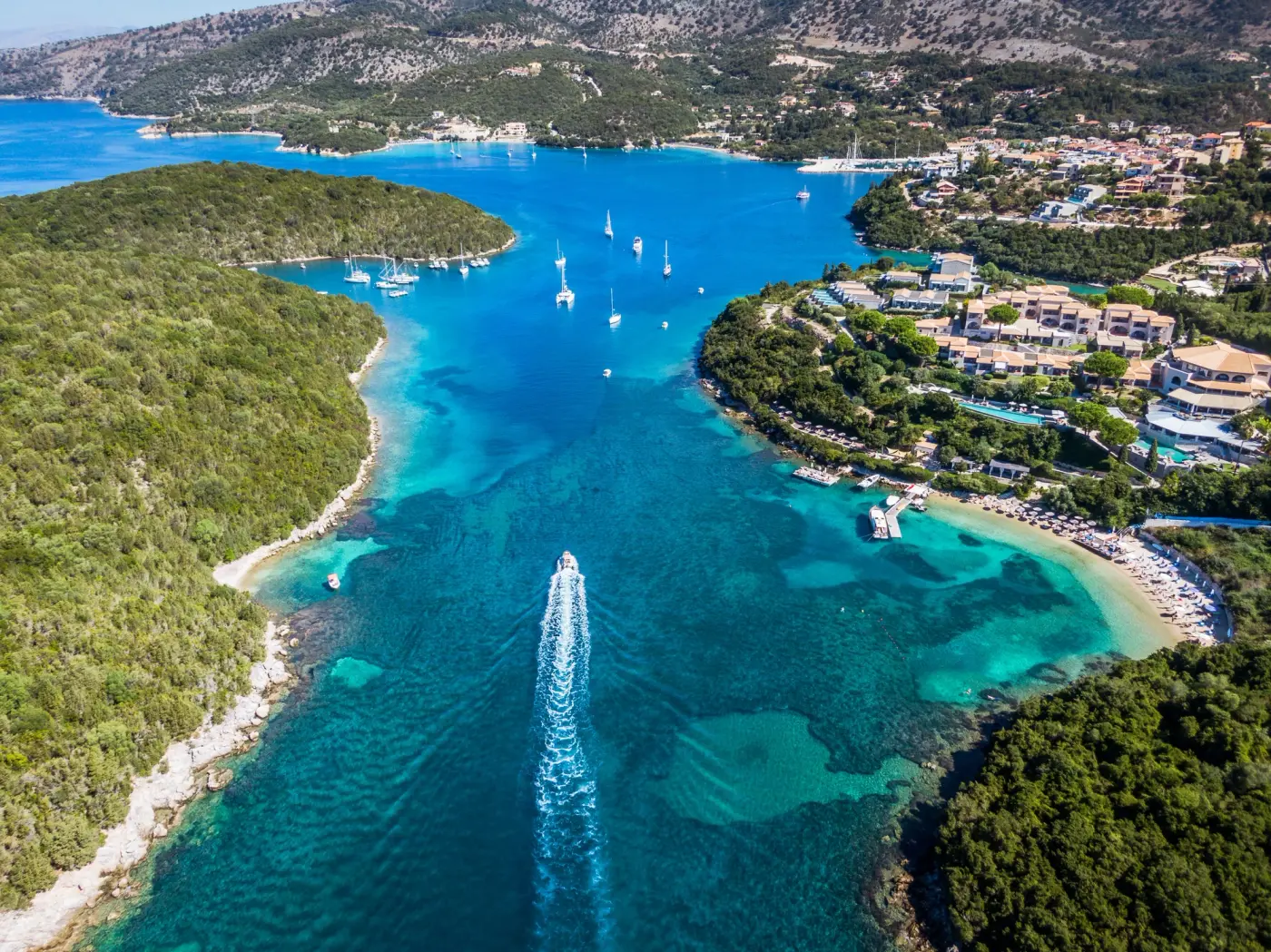 Aerial view of sailing yachts anchored in the turquoise Sivota channel, Ionian Sea, Greece