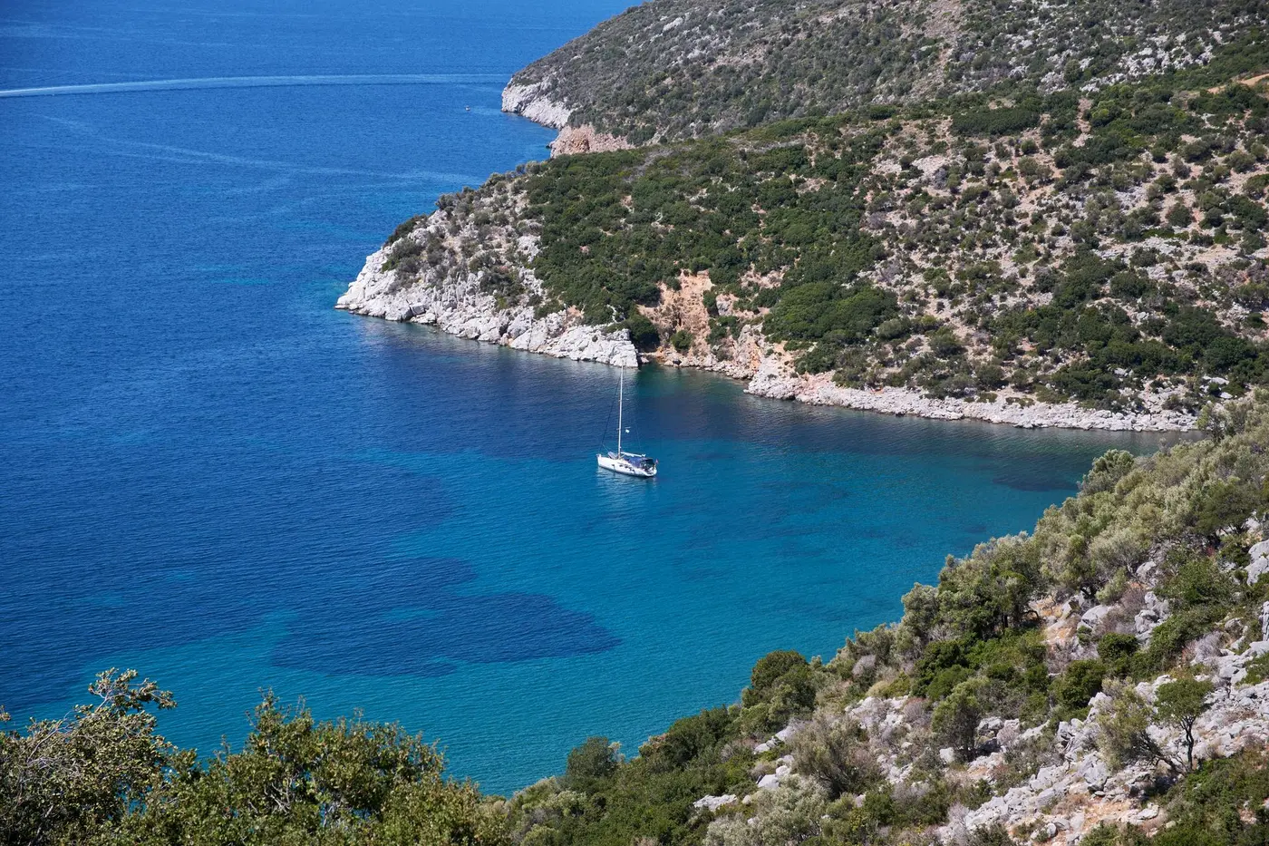 A single sailing yacht at anchor alone in a quiet bay in Greece, the whole cove to itself. Photo by Nils Rotura, Pexels 38016319