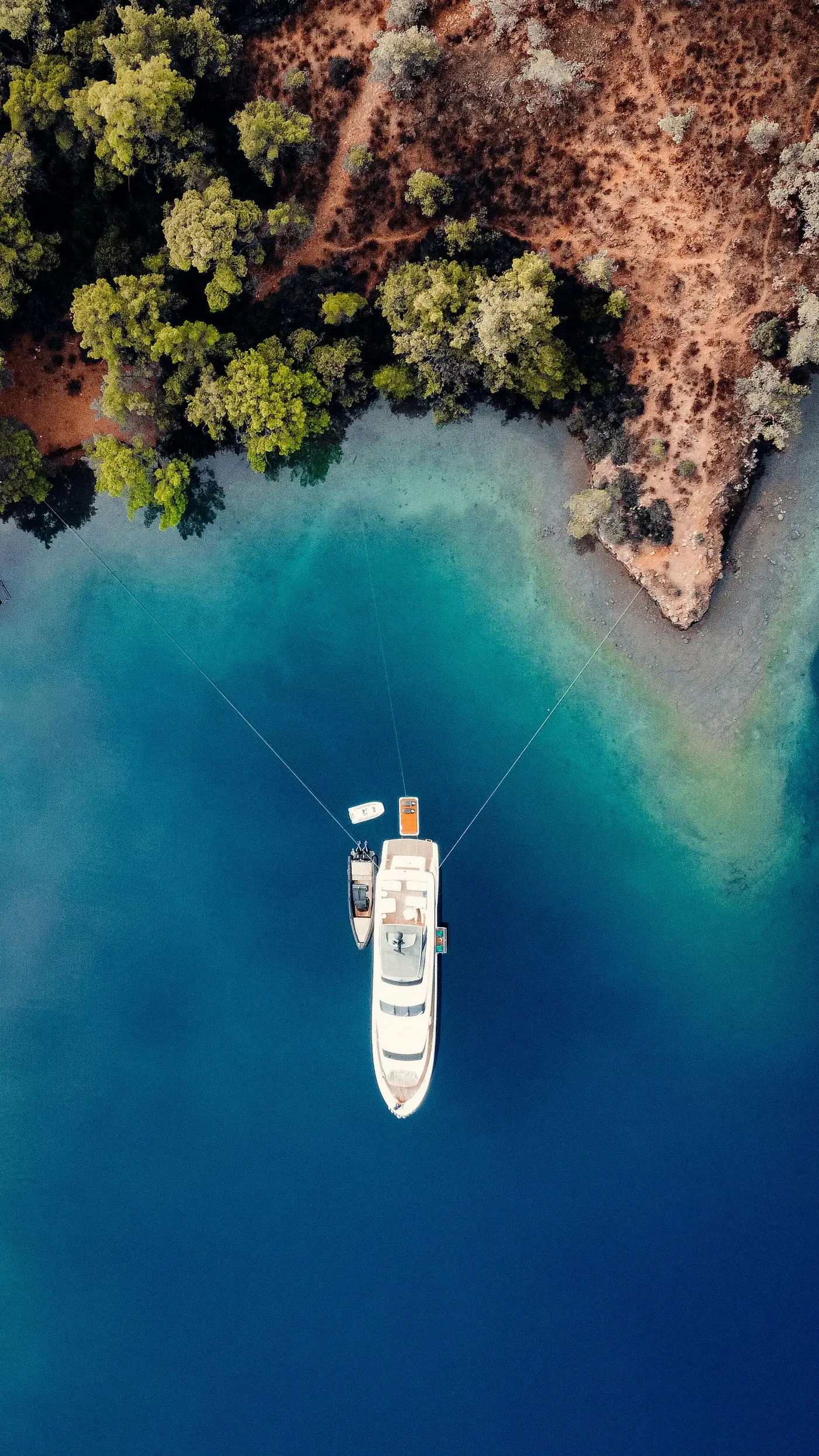 Crewed motor yacht cruising between Cycladic islands in the Aegean Sea at sunrise