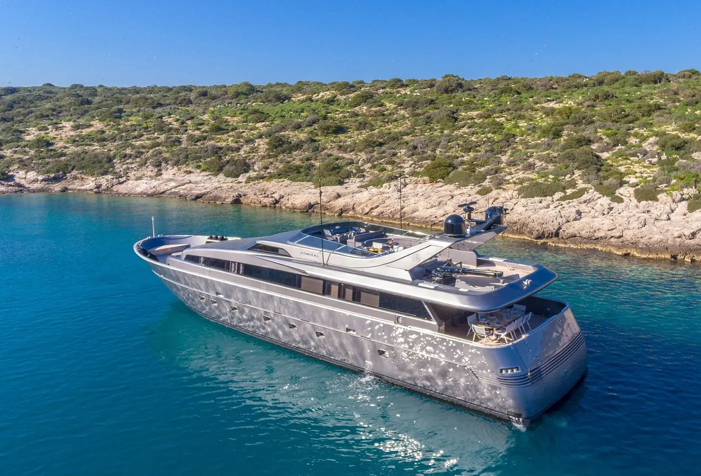 M/Y SUMMER FUN, a 31 metre Admiral motor yacht on the George Yachts list, at anchor in a pine-fringed cove in Greek waters, seen from above
