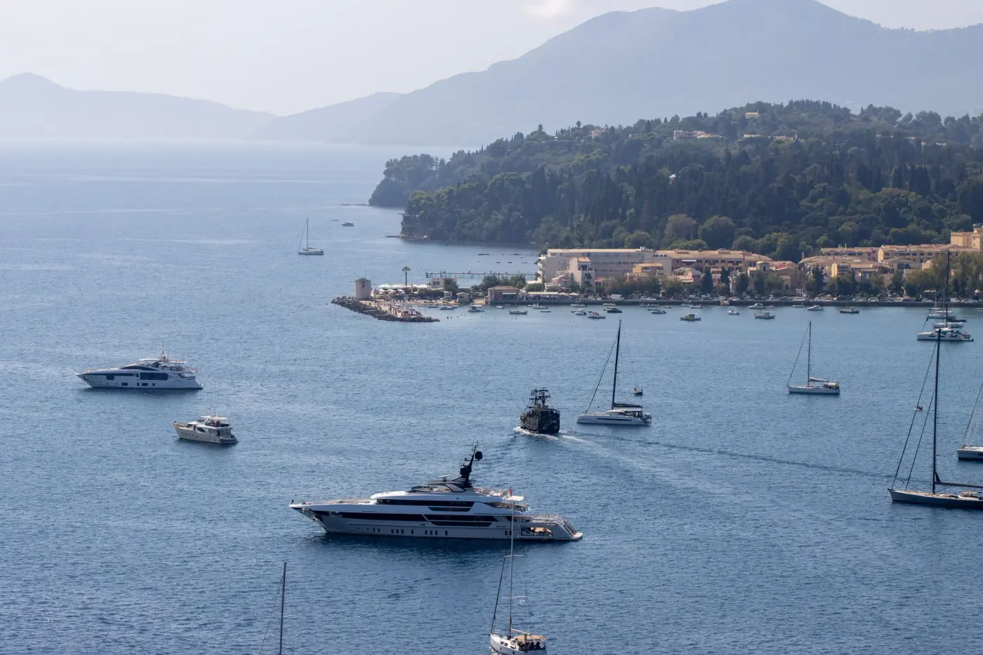 Motor yachts, sailing yachts and a superyacht at anchor in a bay off Corfu, Greece (photo Efrem Efre, Pexels 33849212)