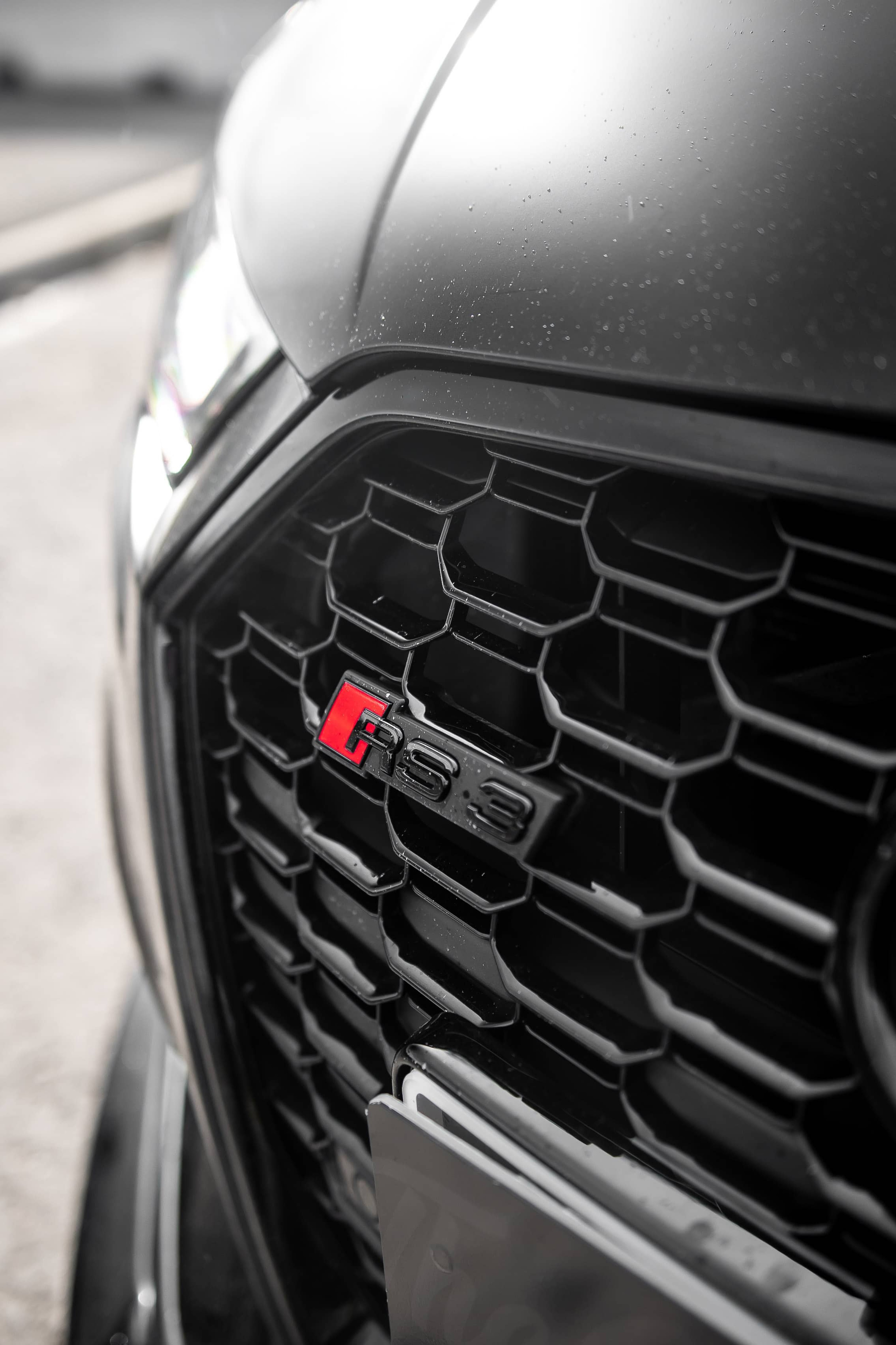 A close-up view highlights the black honeycomb grille and RS3 emblem of a custom Forge Audi RS3.